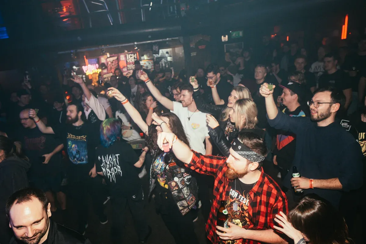 Begeistertes Publikum feiert mit erhobenen Drinks